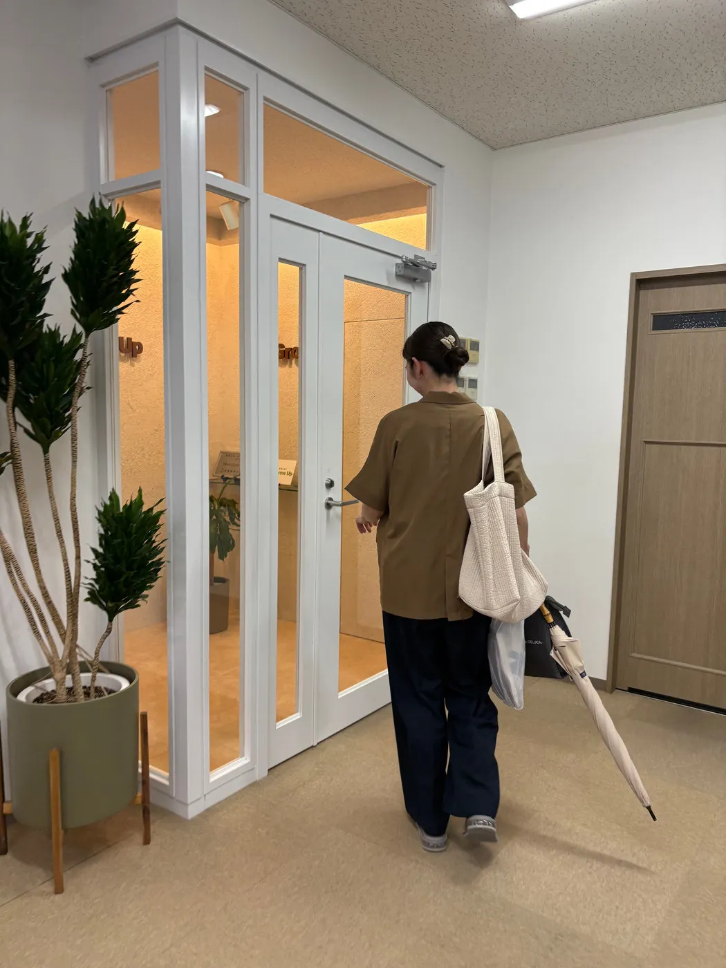 ガラスドアから退社するスタッフ